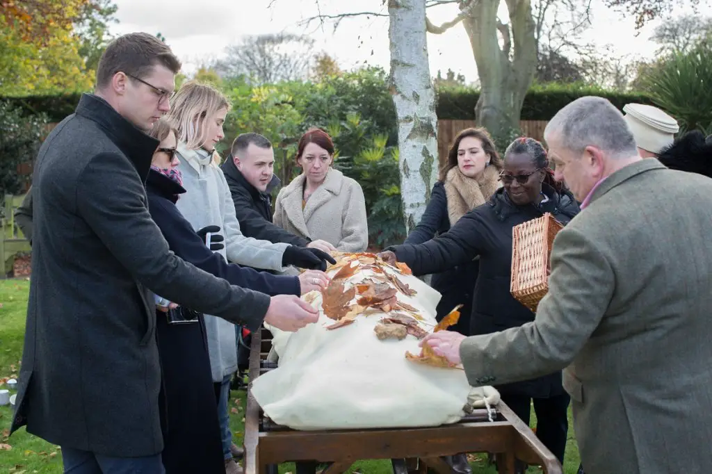 putting flowers on casket at cemetery