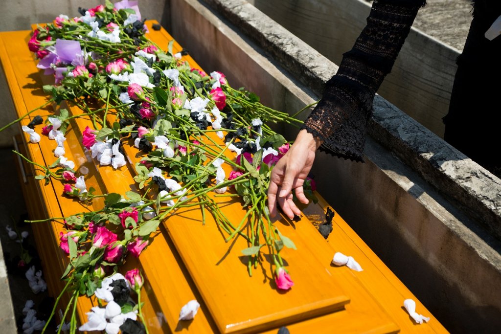Putting flowers on casket at grace