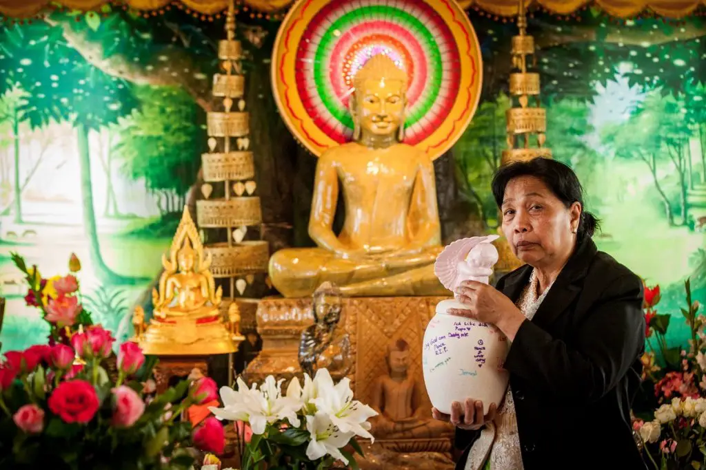 Mother embracing urn of her sone